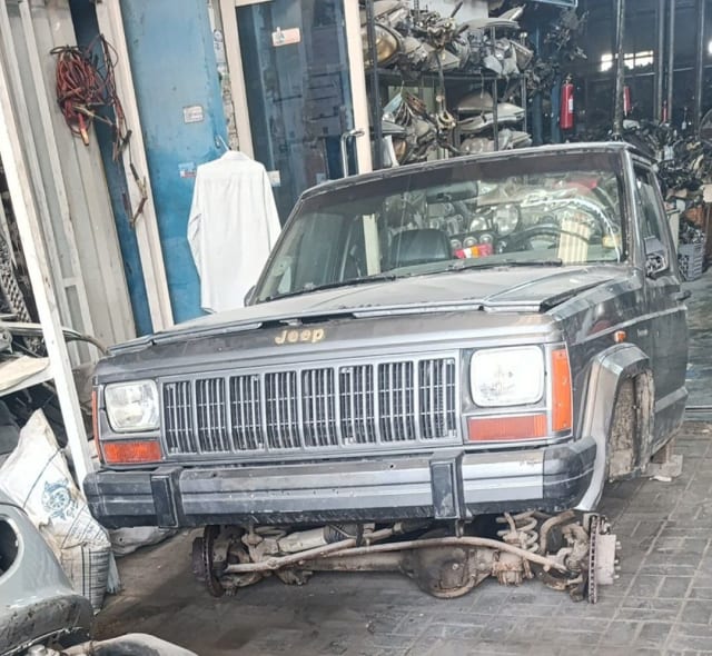 Dark grey Jeep Cherokee SUV halfcut front — grille, headlights, bumper and fenders, Sharjah market