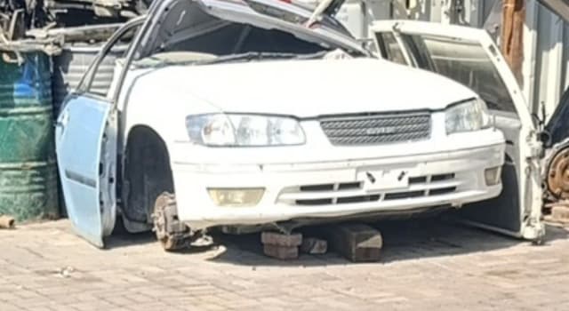 White Toyota Camry sedan halfcut front — bumper, grille and headlights, on blocks, Sharjah market