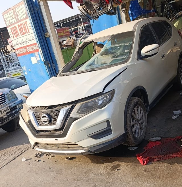 White Nissan X-Trail SUV car for parts — front bumper, grille, headlights and alloy wheels, Sharjah market