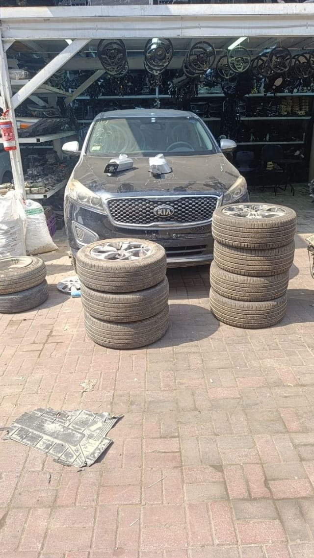 Dark grey Kia Sorento SUV front end with grille, headlights and bumper, plus stacked alloy wheels, Sharjah market