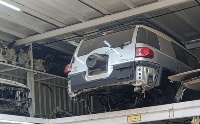 Silver Toyota Sequoia SUV rear halfcut — tail light, quarter panel and roof rack, Sharjah market