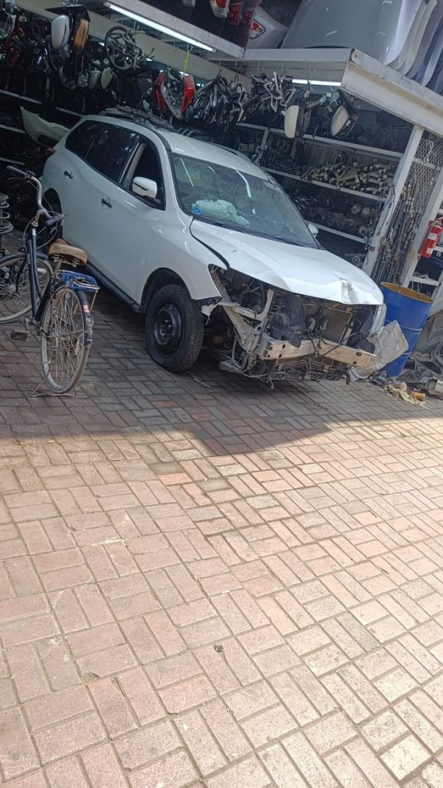 White Nissan Pathfinder SUV halfcut with stripped front end and exposed engine bay, Sharjah market