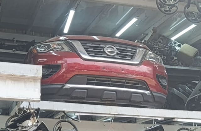 Red Nissan Pathfinder SUV front cut — bumper, grille and headlights, Sharjah market