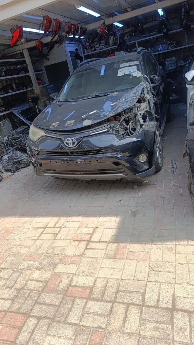 Black Toyota RAV4 SUV front cut for parts — bumper, grille, headlights and open engine bay, Sharjah market