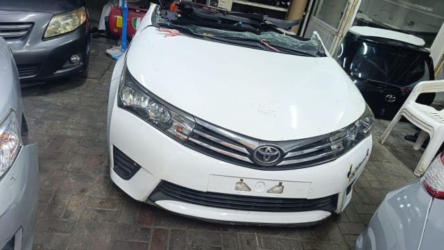 White Toyota Corolla sedan front halfcut — bumper, chrome grille, headlights and hood, Sharjah market