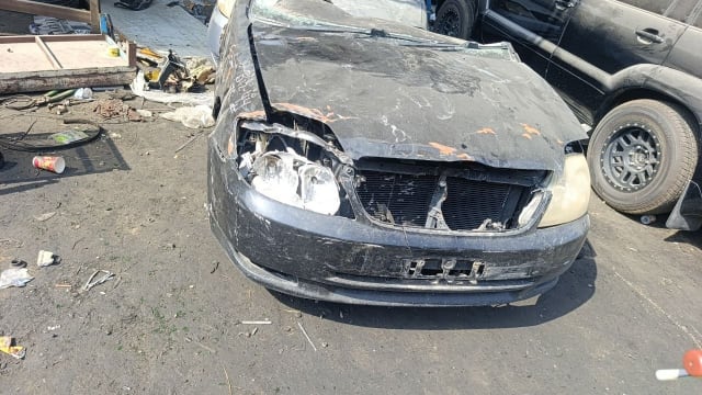 Black Toyota Corolla sedan front halfcut — bumper, headlights, grille and radiator, Sharjah market