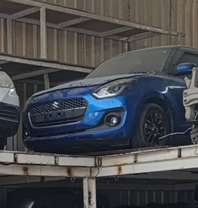 Blue Suzuki Swift hatchback front halfcut — bumper, grille, headlights and alloy wheel, Sharjah market