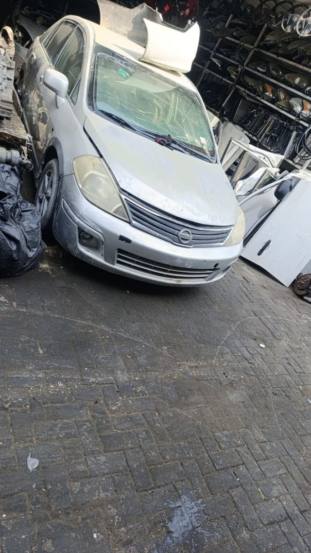 Silver Nissan Tiida hatchback front cut — bumper, grille, headlights and hood, Sharjah market
