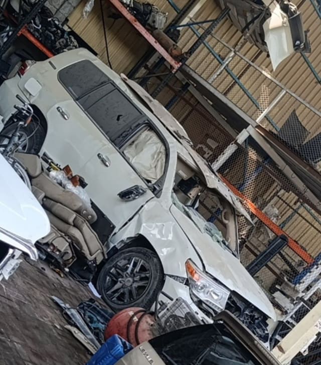 White Lexus LX570 halfcut with front damage — headlights, wheel and beige seats, Sharjah market