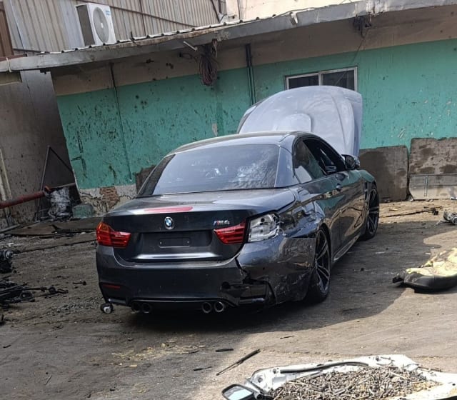 Dark grey BMW M4 convertible car for parts, rear view — bumper, tail lights, trunk and alloy wheels, Sharjah market