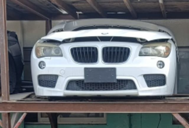 White BMW X1 SUV front halfcut — bumper, kidney grille, headlights and hood, Sharjah market