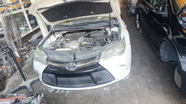 White Toyota Camry sedan front halfcut — bumper, grille, headlights and engine bay, Sharjah market