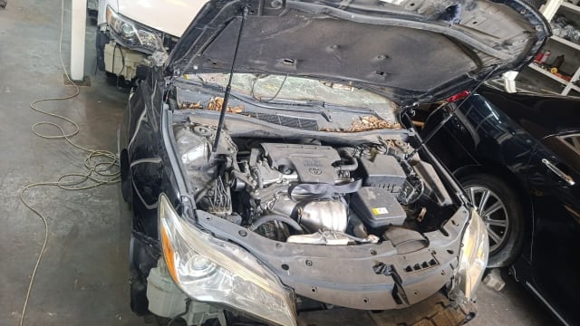 Black Toyota Camry sedan front halfcut — engine bay, headlights and radiator support, Sharjah market