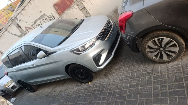 Silver Suzuki Ertiga MPV car for parts — front bumper, grille and headlights, Sharjah market