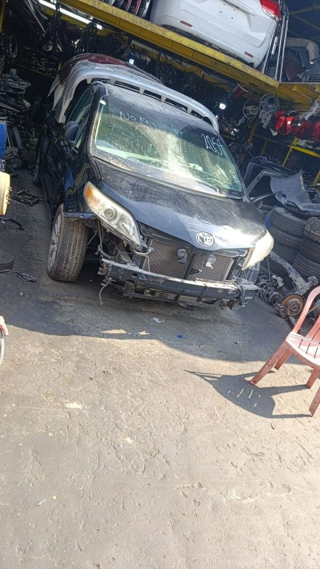 Black Toyota Sienna minivan front halfcut — headlights, hood and exposed radiator support, Sharjah market