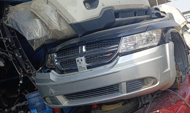 Dark blue Dodge Journey front halfcut with silver bumper, grille and headlight at Sharjah parts market
