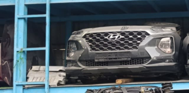 Dark grey Hyundai Santa Fe front halfcut — bumper, grille and headlights on a rack, Sharjah market