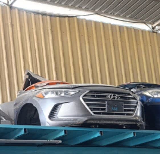 Silver Hyundai Elantra front halfcut with bumper, grille, hood and headlights on a rack, Sharjah market