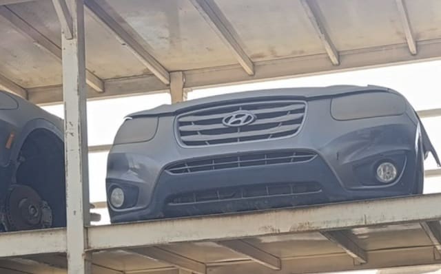 Grey Hyundai Santa Fe front nose cut on a rack: bumper, chrome grille, headlights and fog lights, Sharjah market