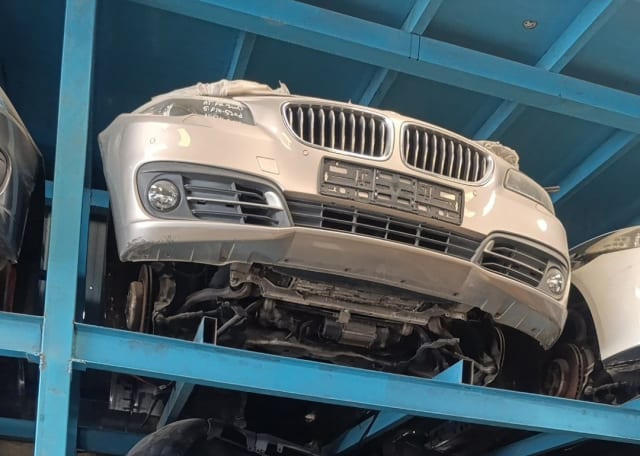 Silver BMW 5-Series front halfcut on a rack — bumper, kidney grille, fog lights and suspension, Sharjah market