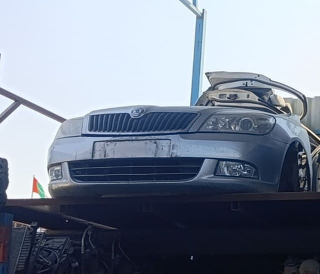 Silver Skoda Octavia front halfcut with bumper, grille, headlights and fog lights on a rack, Sharjah market