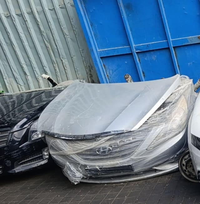 Silver Hyundai Sonata front halfcut in plastic wrap: hood, bumper, grille and headlight, Sharjah market