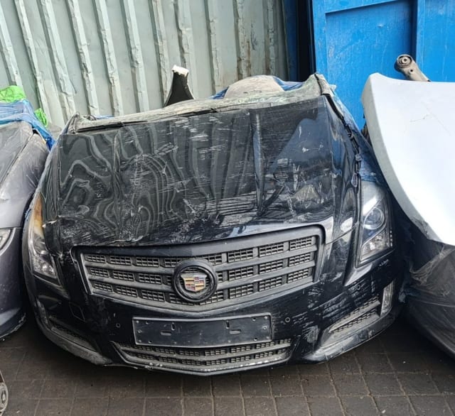 Black Cadillac ATS sedan front halfcut — hood, grille, headlights and bumper in plastic wrap, Sharjah market