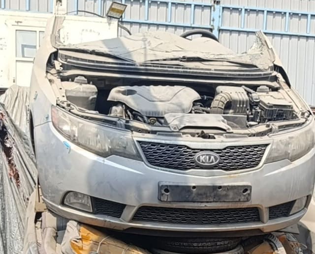 Silver Kia Cerato sedan front halfcut — bumper, grille, headlights and open engine bay, Sharjah market
