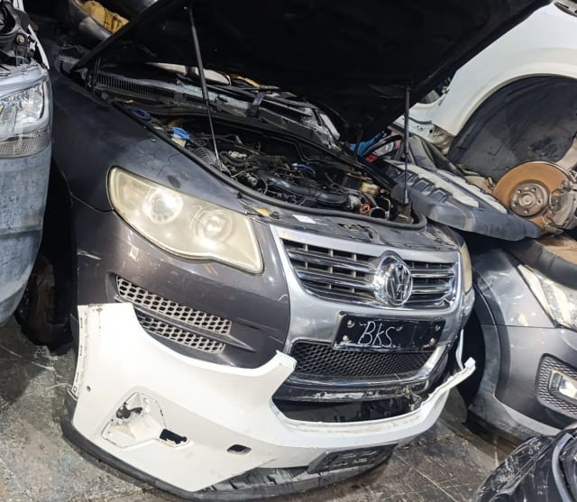 Dark grey VW Touareg front halfcut, hood open, engine, headlights and chrome grille, Sharjah market