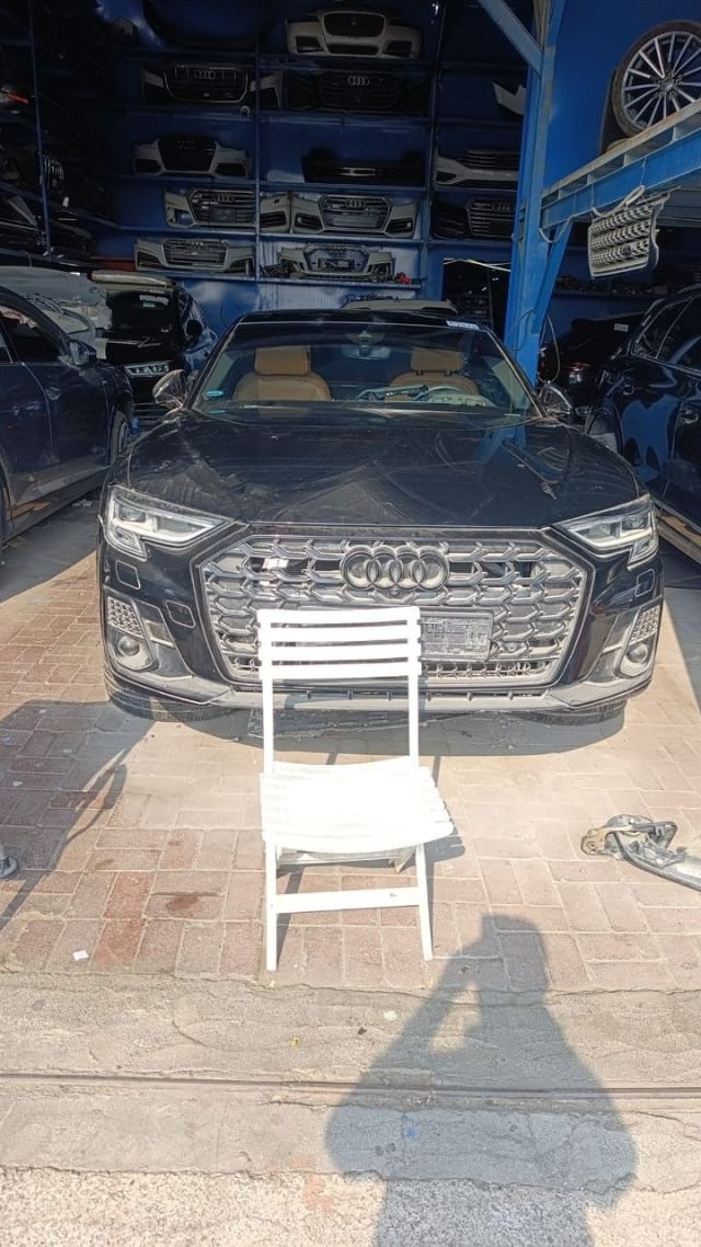 Black Audi A8 sedan halfcut front view: grille, LED headlights, bumper and hood, Sharjah market