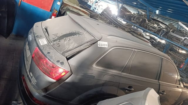 Dusty grey Audi Q7 SUV for parts, rear view with tailgate, tail light and side doors, Sharjah market