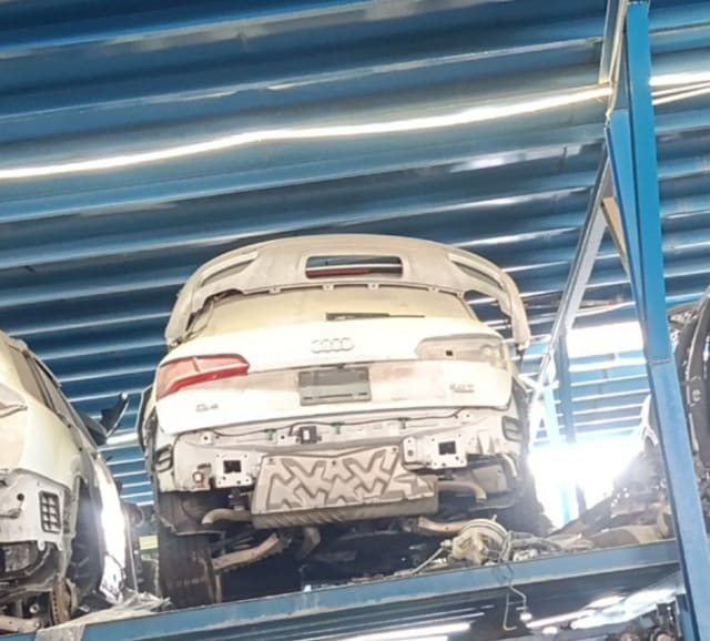 White Audi Q5 rear halfcut on a rack, with tailgate, taillight, spoiler and exhaust, Sharjah market
