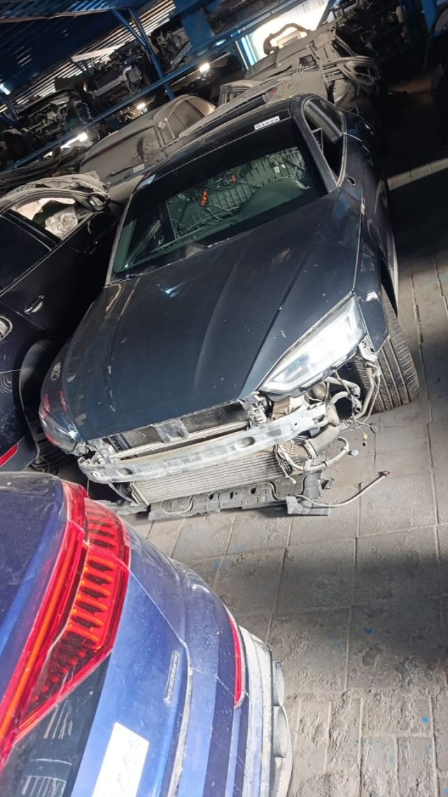 Dark grey Audi A5 for parts, front bumper off — hood, headlights and radiator visible, Sharjah market