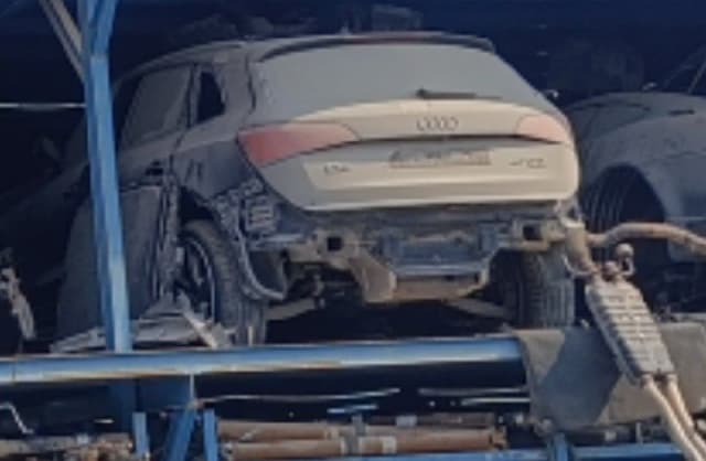 Dusty silver Audi Q5 SUV for parts, rear view with tailgate and taillights, bumper removed, Sharjah market