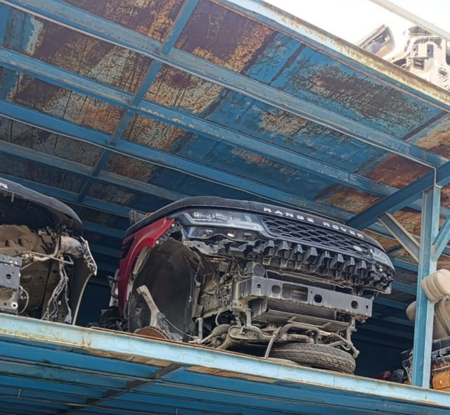 Red Range Rover Sport front halfcut with hood, grille and LED headlights on a rack, Sharjah market