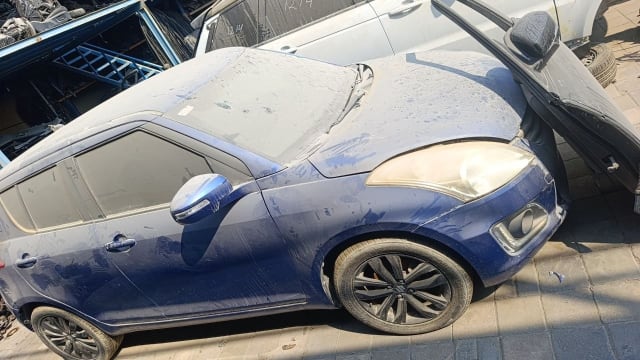 Dusty blue Suzuki Swift hatchback for parts, with hood, headlight, bumper, doors and alloy wheels, Sharjah market