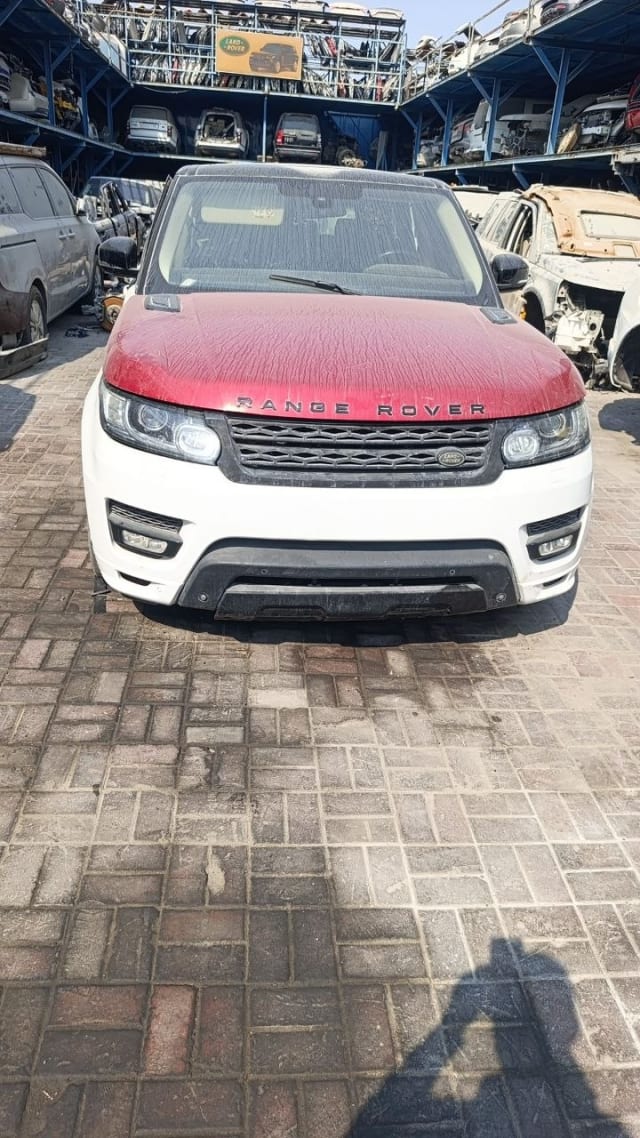 Range Rover Sport halfcut front view: red hood, grille, headlights, white bumper, Sharjah market