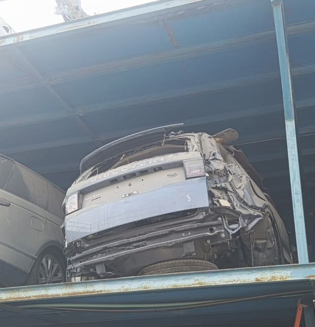 Blue-grey Land Rover Discovery Sport rear halfcut — tailgate and tail lights on a rack, Sharjah market