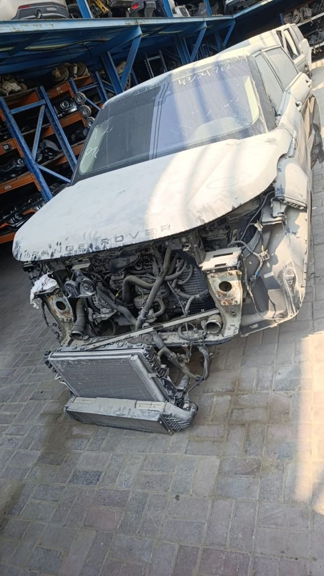 Dusty white Land Rover Range Rover for parts: exposed engine bay, hood and detached radiator, Sharjah market