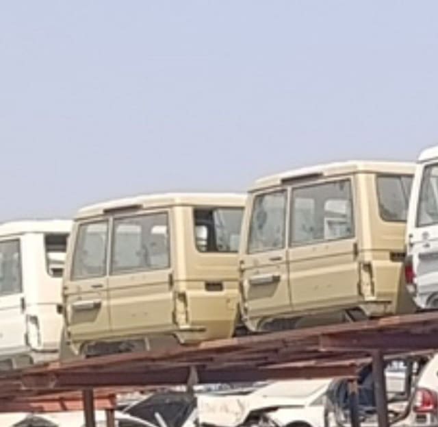 Beige and white Toyota Land Cruiser 70 rear halfcut shells with barn doors stacked on a rack, Sharjah market