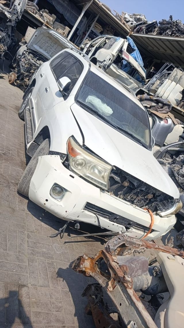White Toyota Land Cruiser SUV for parts — bumper, headlights, hood and exposed radiator, Sharjah market