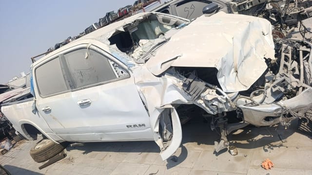 White RAM 1500 crew cab for parts — intact doors and bed, crushed front end and hood, Sharjah market
