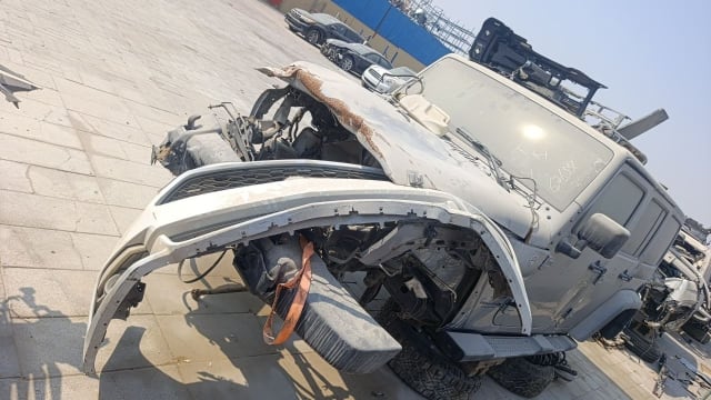 Silver Jeep Wrangler car for parts, crushed front end, bumper, hood and doors visible, Sharjah market