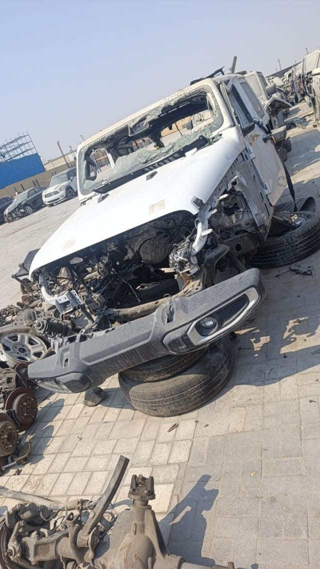 White Jeep Wrangler halfcut with hood, detached front bumper and exposed engine bay, Sharjah market