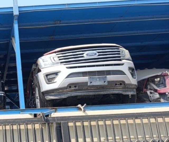 White Ford Expedition front halfcut on a rack — chrome grille, headlights and bumper, Sharjah market