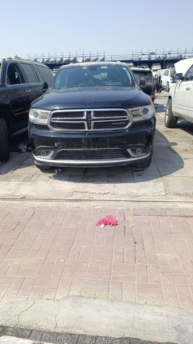 Black Dodge Durango SUV front view with grille, headlights, hood and scuffed bumper, Sharjah market