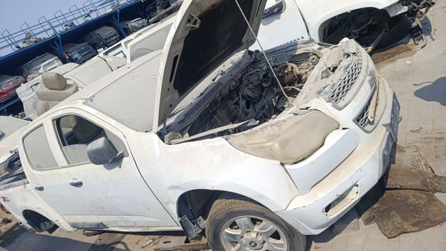 White Chevrolet Colorado pickup for parts, hood open showing engine, bumper and headlights, Sharjah market