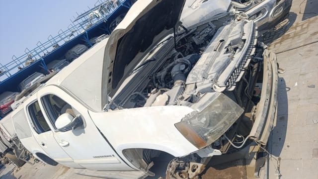 White Chevrolet Suburban for parts — open hood, engine bay, grille and headlight, Sharjah market