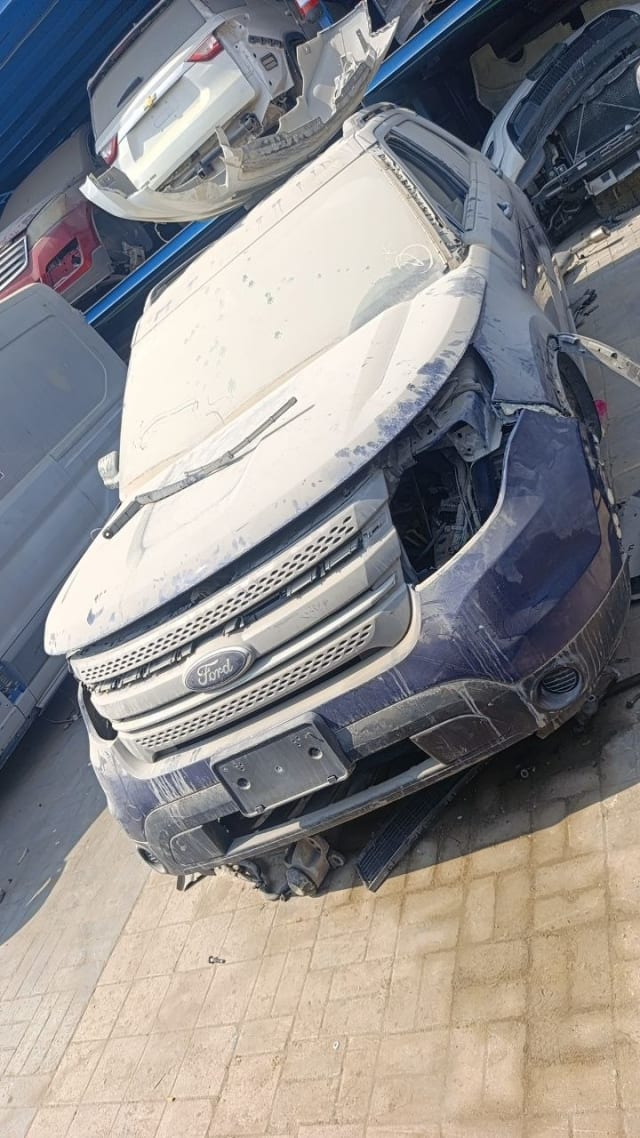 Dusty dark blue Ford Explorer car for parts: hood, grille and front bumper, headlights missing, Sharjah market