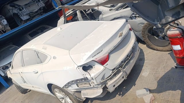White Chevrolet Impala sedan for parts, rear view with trunk lid, taillight and V6 badge, Sharjah market
